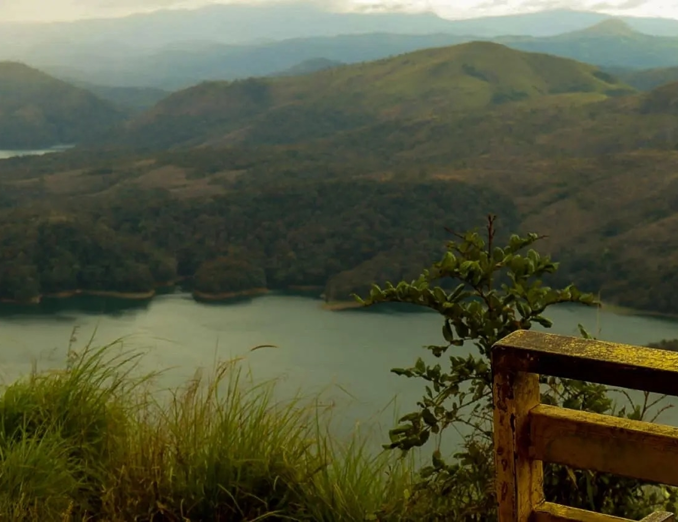 Misty hills and a lake seen from a wooden railing