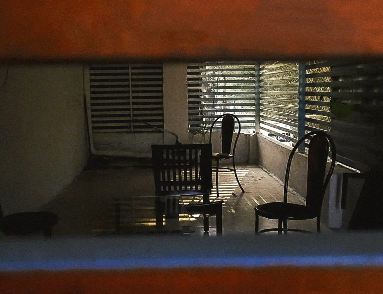 Light falling across chairs on a quiet balcony