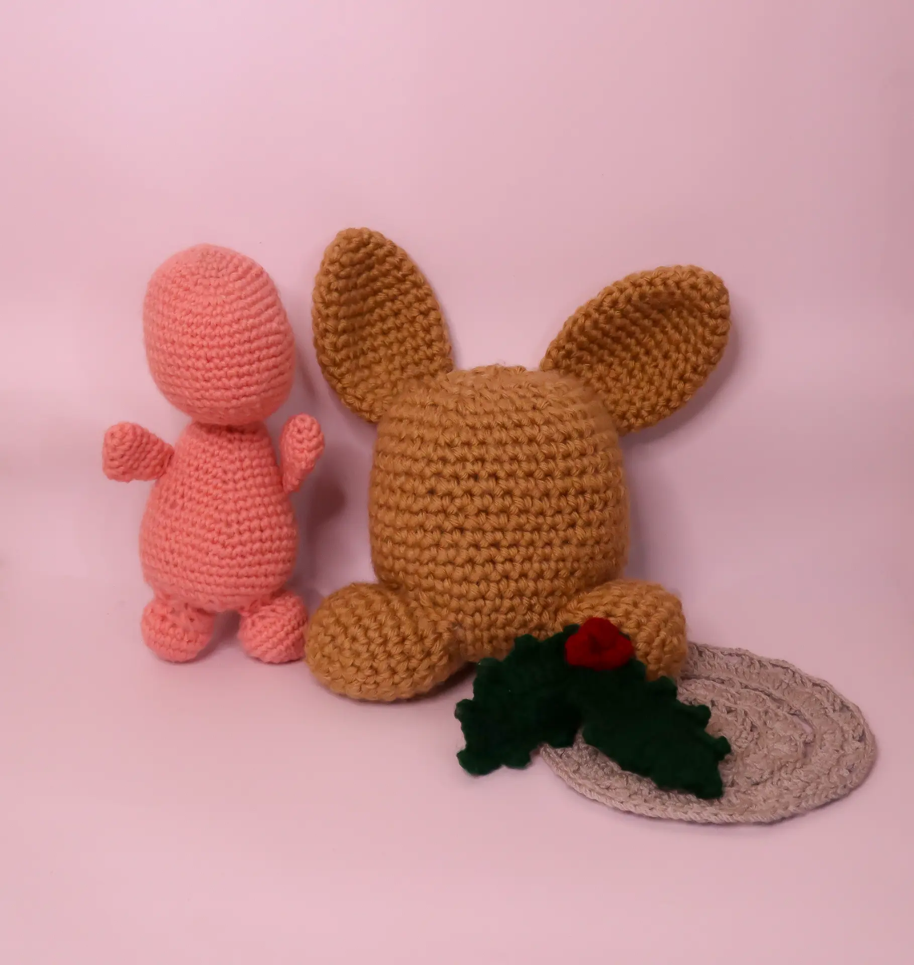 Handmade crochet amigurumi figures on a pink background